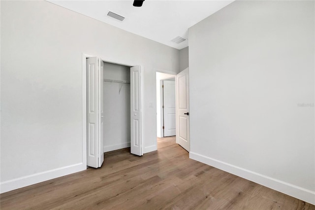 unfurnished bedroom featuring light hardwood / wood-style floors, a closet, and ceiling fan