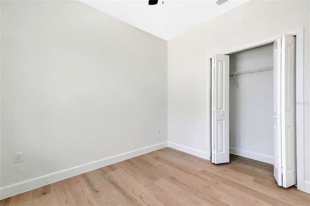 unfurnished bedroom featuring light hardwood / wood-style flooring, a closet, and ceiling fan