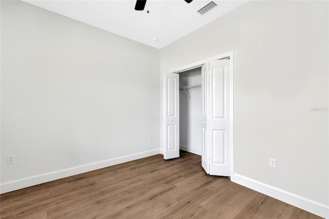 unfurnished bedroom featuring a closet, hardwood / wood-style floors, and ceiling fan