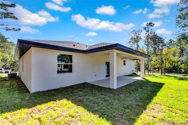 rear view of house featuring a patio, a lawn, and central air condition unit