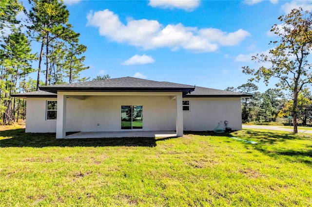 rear view of property with a yard and a patio