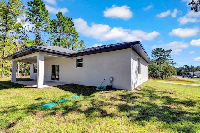 back of property with a yard and a patio area