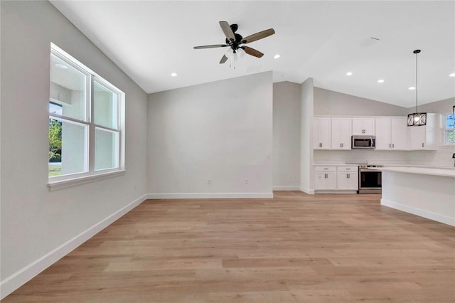 unfurnished living room featuring lofted ceiling, light wood-type flooring, and ceiling fan with notable chandelier