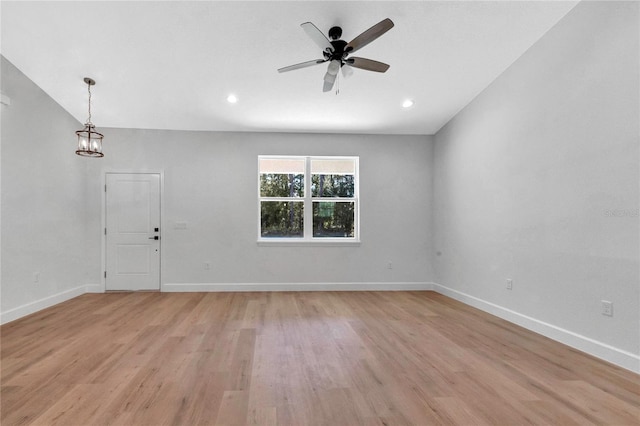 empty room featuring light hardwood / wood-style floors and ceiling fan with notable chandelier