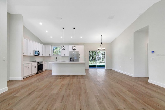 kitchen with appliances with stainless steel finishes, a kitchen island, light hardwood / wood-style floors, decorative light fixtures, and white cabinets