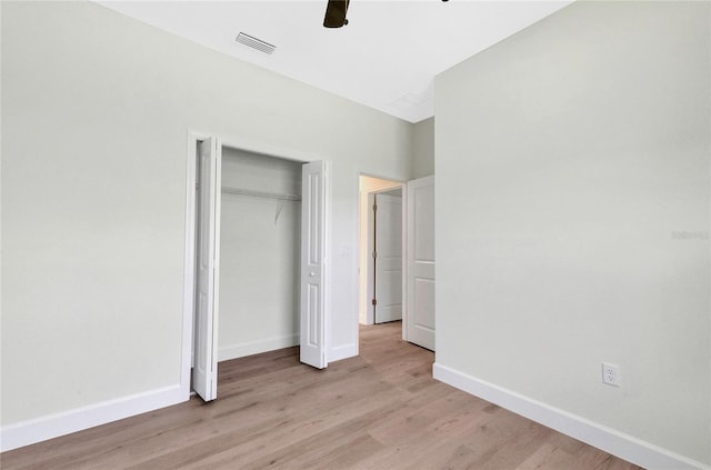 unfurnished bedroom with a closet, light wood-type flooring, and ceiling fan