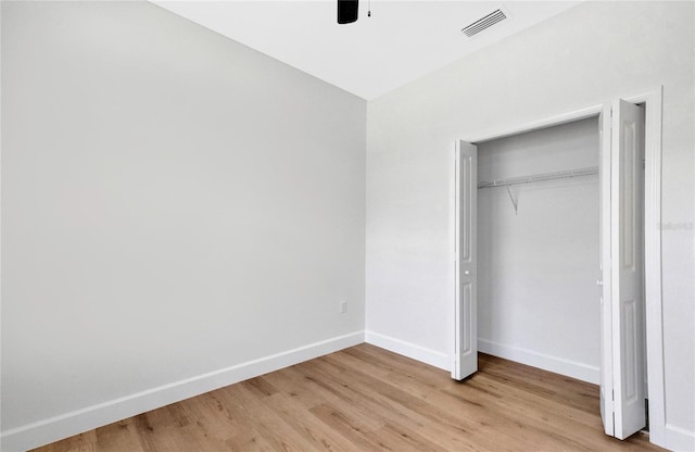 unfurnished bedroom featuring a closet, light wood-type flooring, and ceiling fan