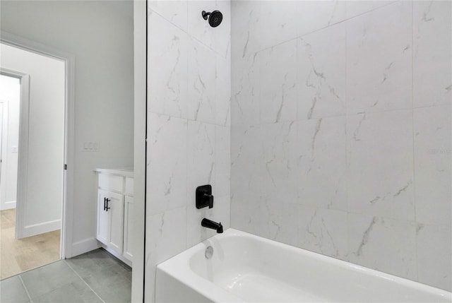 bathroom featuring vanity, tiled shower / bath combo, and tile patterned flooring