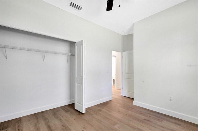 unfurnished bedroom with a closet, light wood-type flooring, and ceiling fan