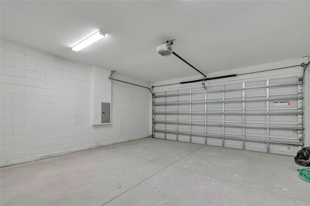 garage with a garage door opener and electric panel