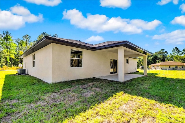 rear view of property with a yard, a patio, and central AC unit