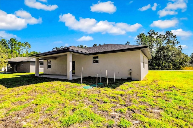 back of property featuring a patio area and a lawn