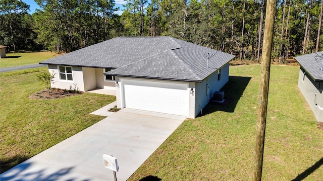 view of front of property featuring central AC, a front yard, and a garage