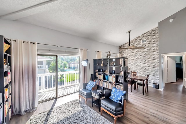 living room featuring a textured ceiling, ceiling fan, hardwood / wood-style floors, and vaulted ceiling