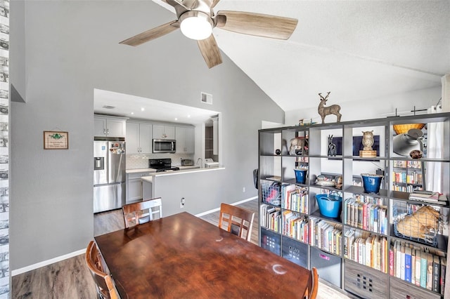 2937 Bough Ave Unit D, Clearwater, FL 33760 - dining room featuring baseboards, ceiling fan, wood finished floors, and high vaulted ceiling