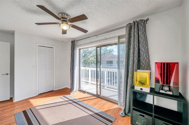 interior space featuring access to exterior, ceiling fan, a closet, and wood-type flooring