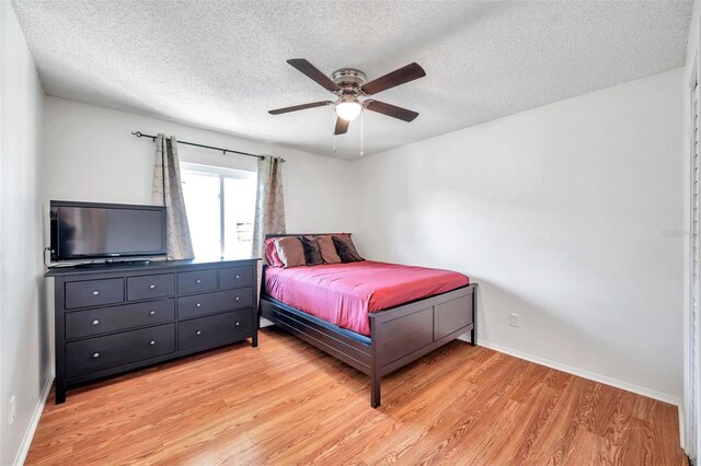 2937 Bough Ave Unit D, Clearwater, FL 33760 - bedroom featuring light wood-style floors, a textured ceiling, baseboards, and a ceiling fan