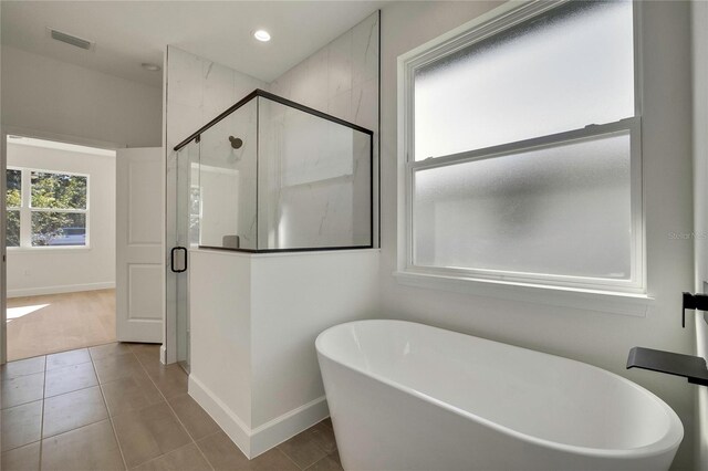 bathroom with separate shower and tub and tile patterned flooring