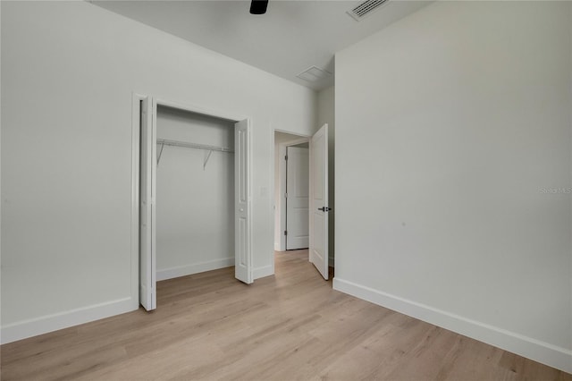 unfurnished bedroom with a closet, light wood-type flooring, and ceiling fan