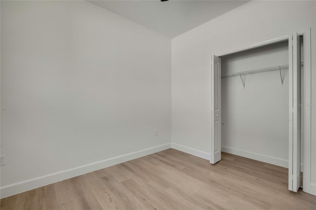 unfurnished bedroom with a closet and light wood-type flooring