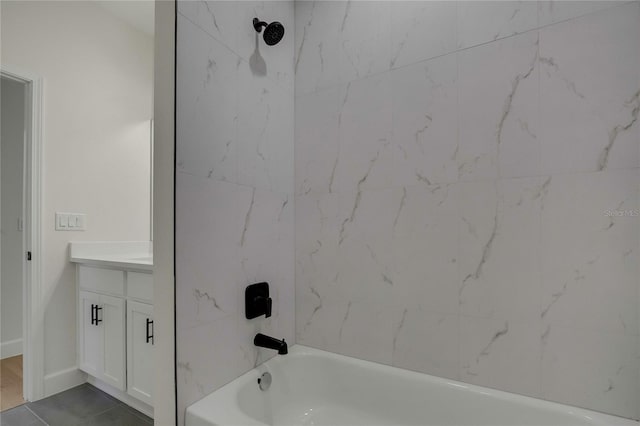 bathroom with vanity, tiled shower / bath combo, and tile patterned flooring