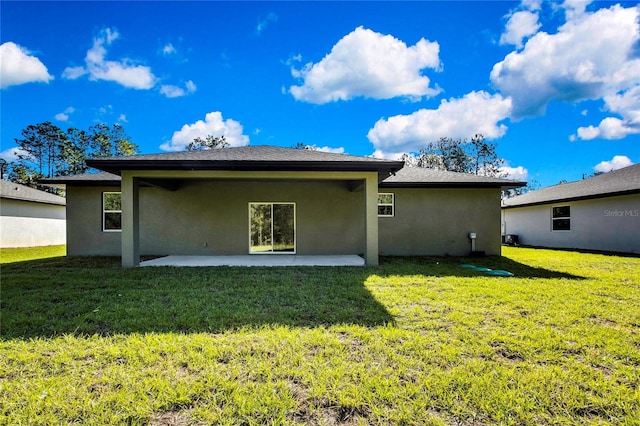 back of house with a patio area and a lawn