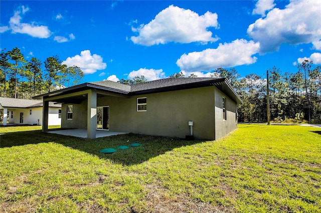 rear view of property with a yard and a patio area