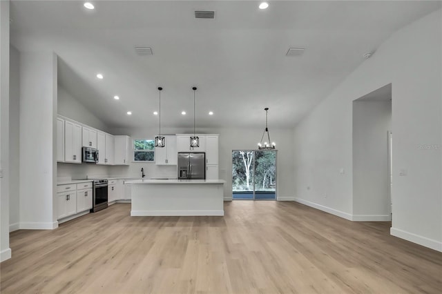 kitchen with light hardwood / wood-style flooring, stainless steel appliances, a center island, pendant lighting, and white cabinetry