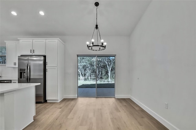 unfurnished dining area featuring light hardwood / wood-style floors and a notable chandelier