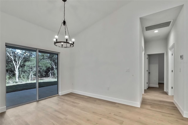 unfurnished dining area with a notable chandelier and light wood-type flooring