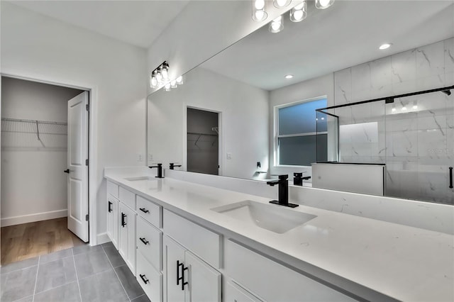 bathroom with vanity, a shower with shower door, and tile patterned floors