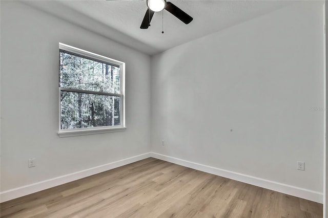 spare room featuring a textured ceiling, light wood-type flooring, and ceiling fan