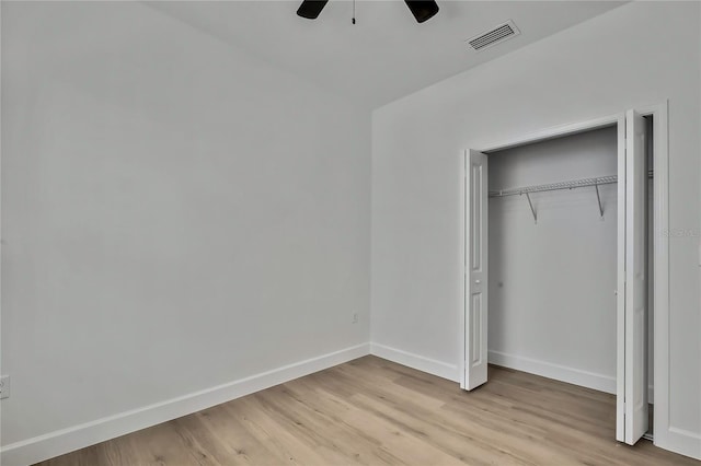 unfurnished bedroom featuring a closet, light hardwood / wood-style floors, and ceiling fan