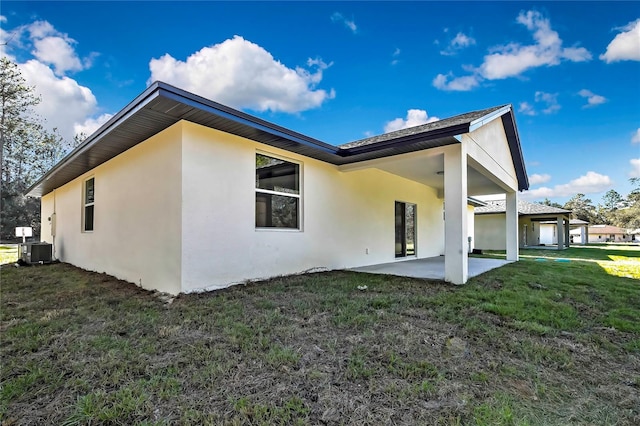8118 N Santos Dr, Citrus Springs, FL 34434 - rear view of property with stucco siding, a patio, a yard, and central AC