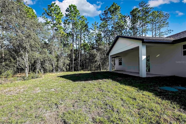 8118 N Santos Dr, Citrus Springs, FL 34434 - view of green lawn featuring a patio and a carport