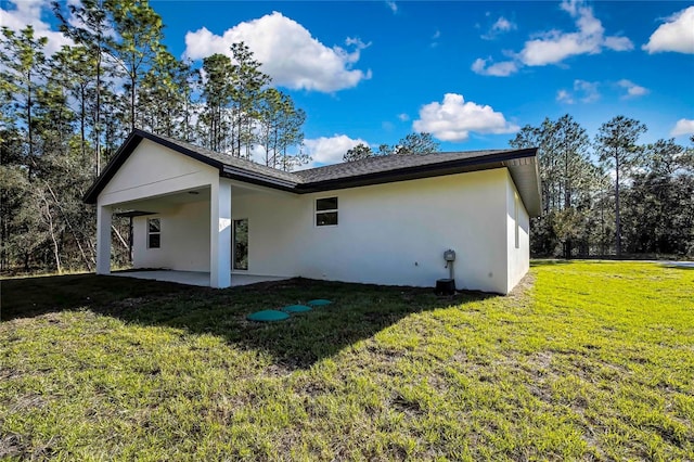8118 N Santos Dr, Citrus Springs, FL 34434 - back of property with stucco siding, a patio area, and a yard