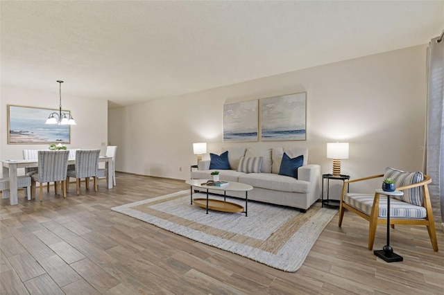 living room featuring a chandelier and light hardwood / wood-style flooring