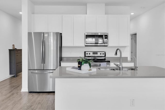 kitchen featuring light hardwood / wood-style floors, white cabinetry, stainless steel appliances, and sink