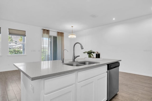 kitchen with white cabinets, a kitchen island with sink, dishwasher, decorative light fixtures, and sink