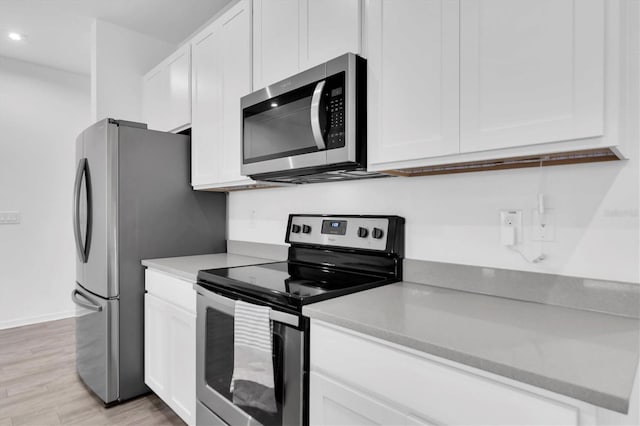 kitchen featuring white cabinets, light hardwood / wood-style flooring, and stainless steel appliances