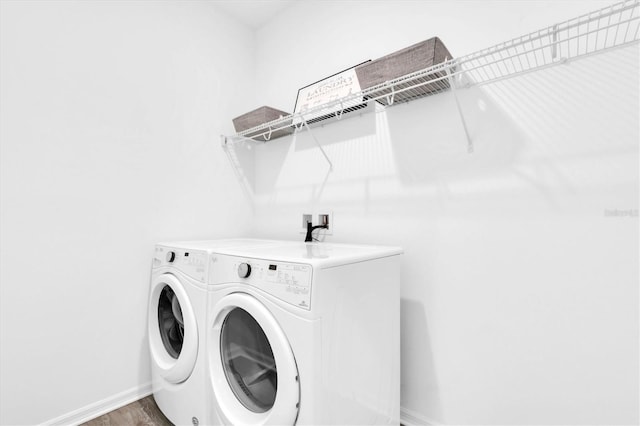 laundry room with washing machine and dryer and hardwood / wood-style flooring