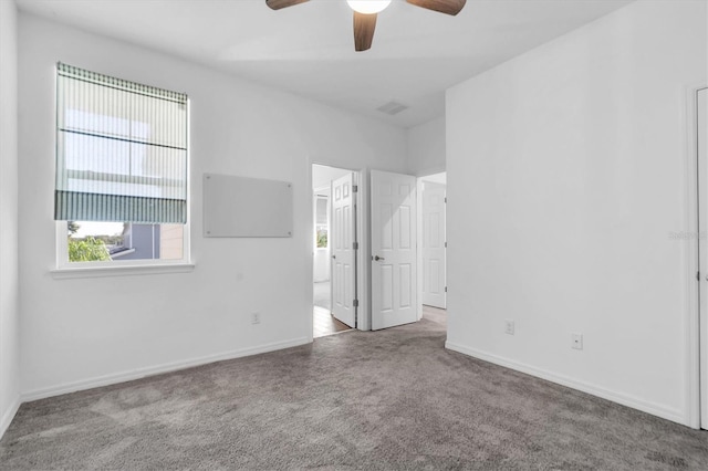 carpeted spare room with ceiling fan