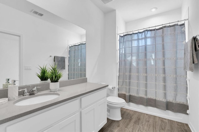 full bathroom featuring vanity, shower / tub combo with curtain, wood-type flooring, and toilet