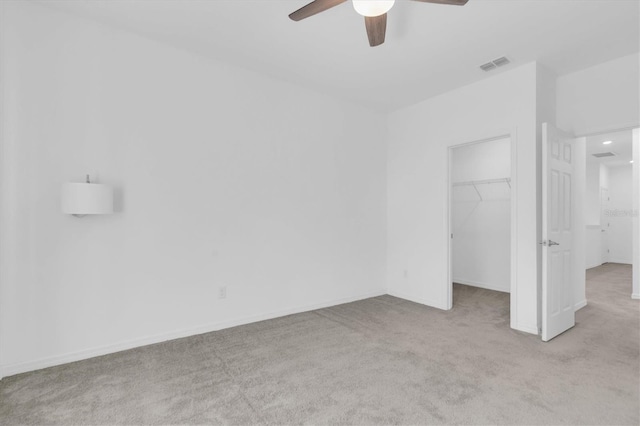 unfurnished bedroom featuring light carpet, a closet, and ceiling fan