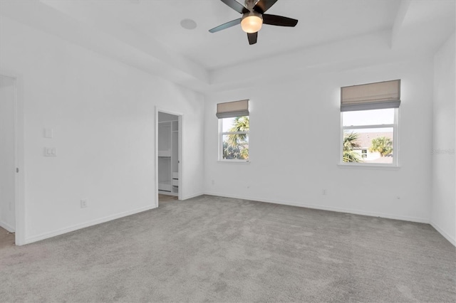 carpeted spare room with ceiling fan and plenty of natural light