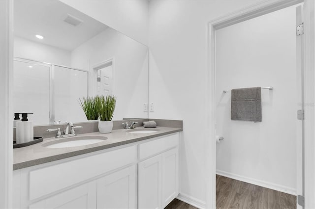 bathroom featuring vanity, hardwood / wood-style flooring, and a shower with shower door