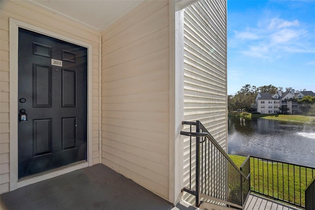 property entrance featuring a yard and a water view