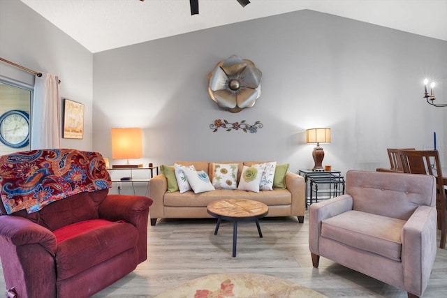 living room with light hardwood / wood-style flooring, ceiling fan, and vaulted ceiling