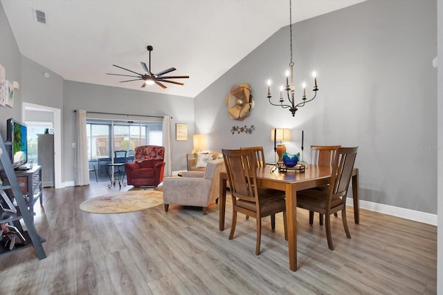 dining room featuring high vaulted ceiling, hardwood / wood-style floors, and ceiling fan with notable chandelier