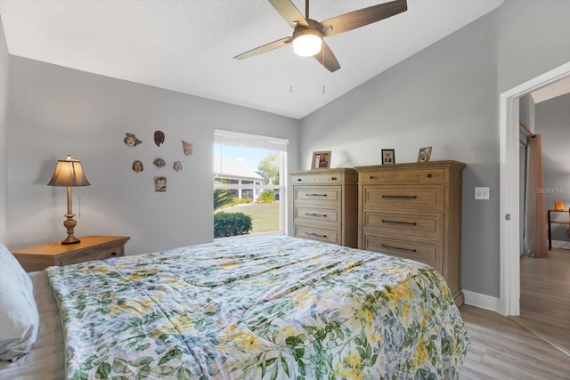 bedroom with light hardwood / wood-style flooring, lofted ceiling, and ceiling fan